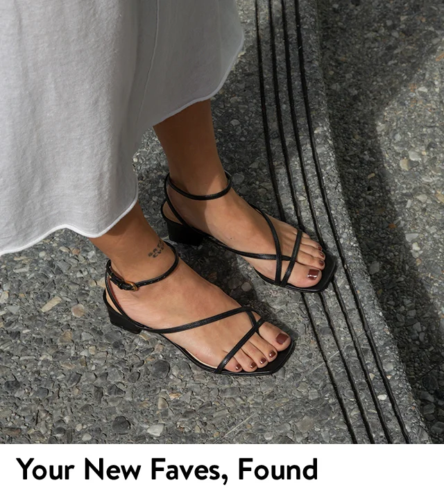 A woman wearing strappy black sandals.
