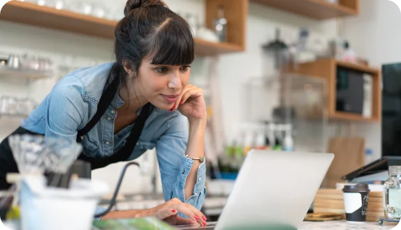 Cafe owner looking at a laptop