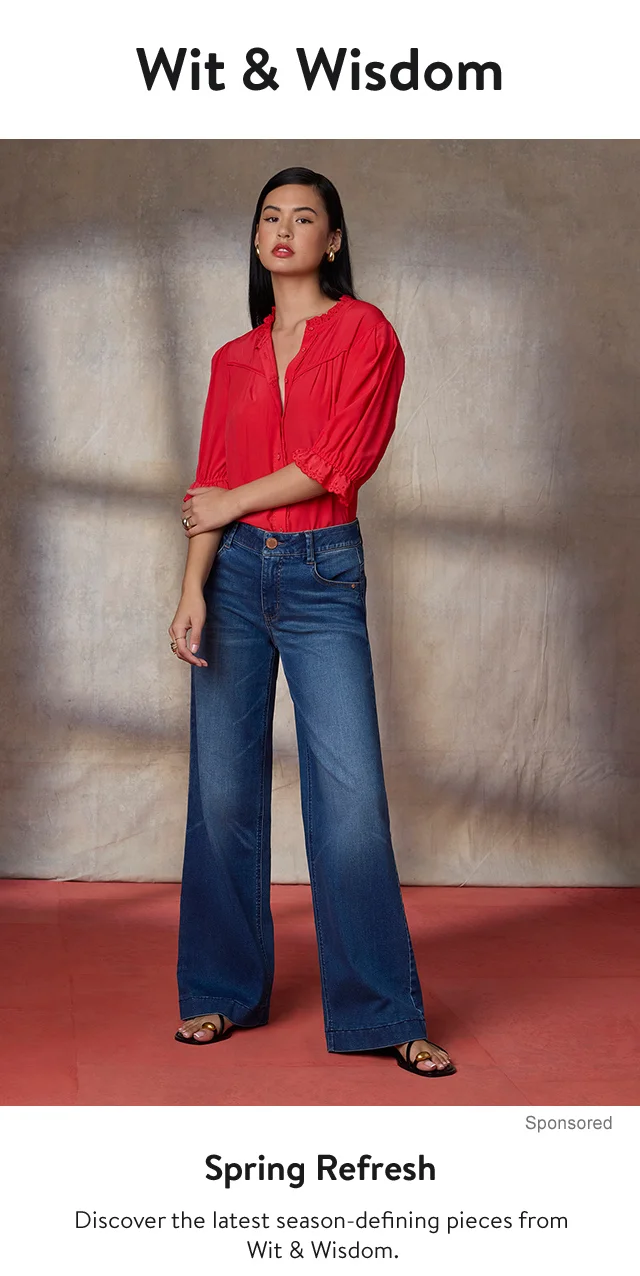 A woman wearing a red shirt and wide-leg jeans.