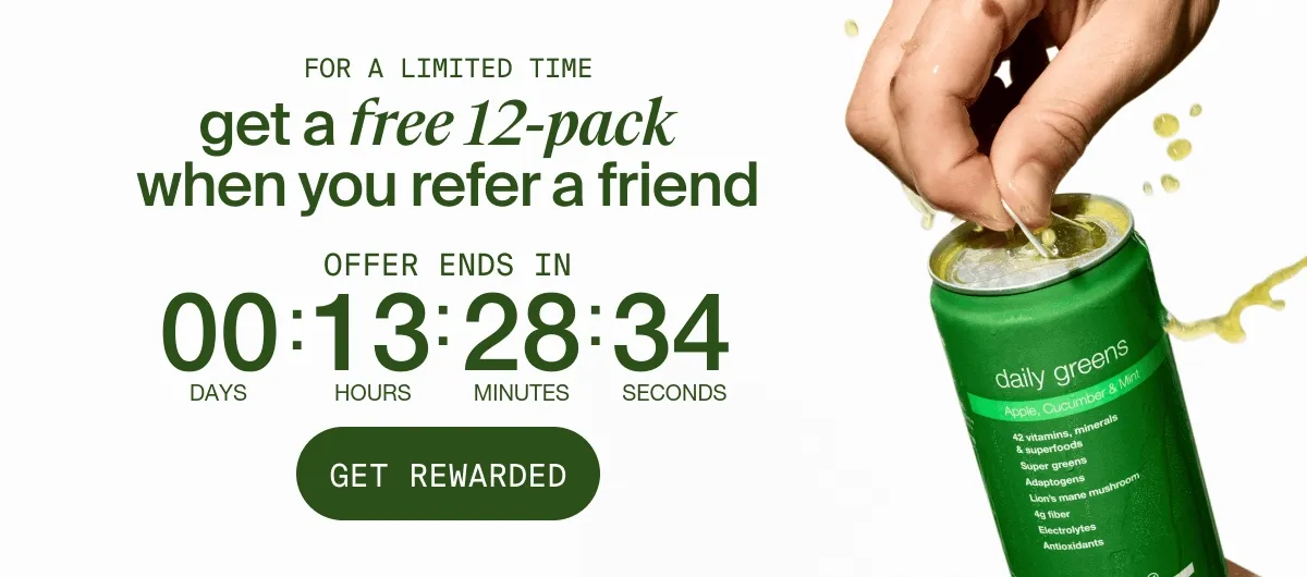 Hand opening a green Huel Daily Greens can with liquid fizzing out. On the left, promotional text reads: 'For a limited time get a free 12-pack when you refer a friend. Offer ends in…' Button below says 'Get Rewarded.' The can shown is Apple, Cucumber & Mint flavor.