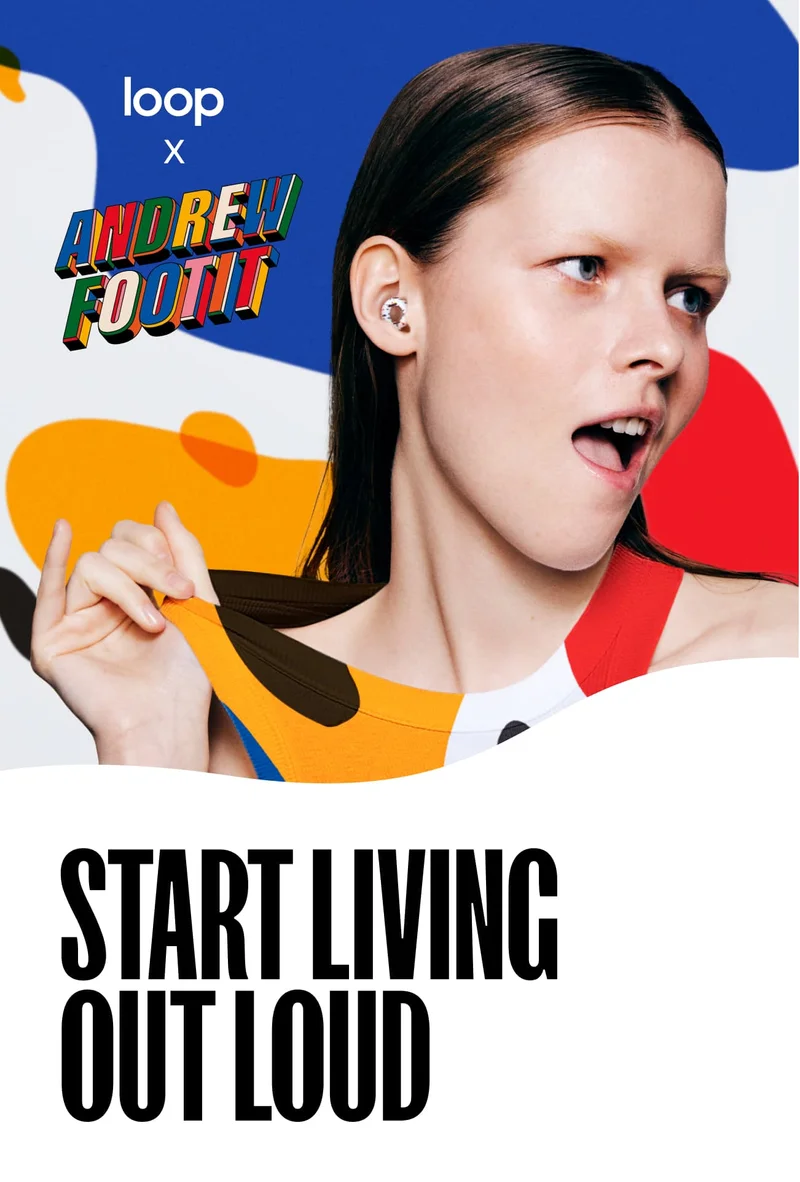 Woman wearing the colorful new Loop x Andrew Footit Experience earplugs against a background with the same vibrant red, blue and yellow colors.