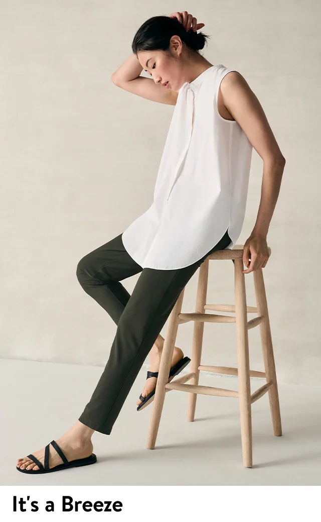 A woman wearing a sleeveless button-up top with black pants.