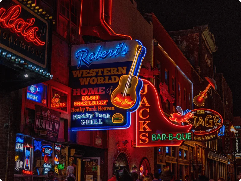 Image Description: A cluster of bright neon bar signs along Nashville’s iconic Lower Broadway thoroughfare
