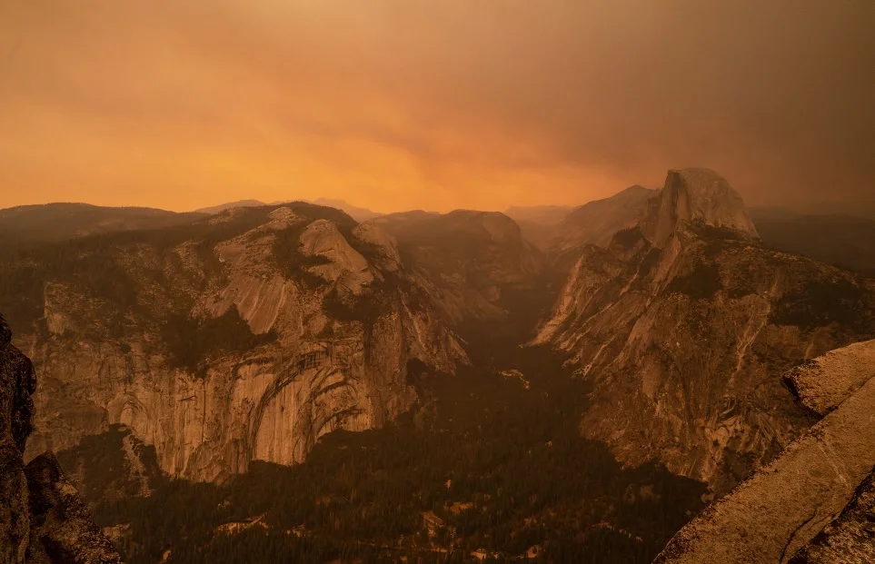 Photo of Yosemite Valley with an orange, smoke-filled sky.
