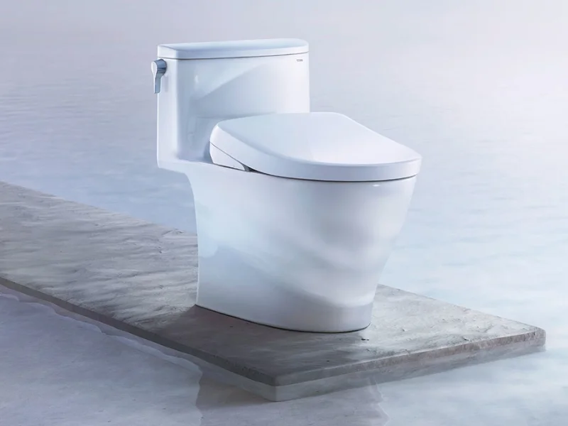 A TOTO WASHLET S7A is displayed on a platform above a body of water.