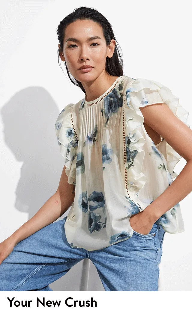 A woman wearing a floral-print blouse with ruffle details.