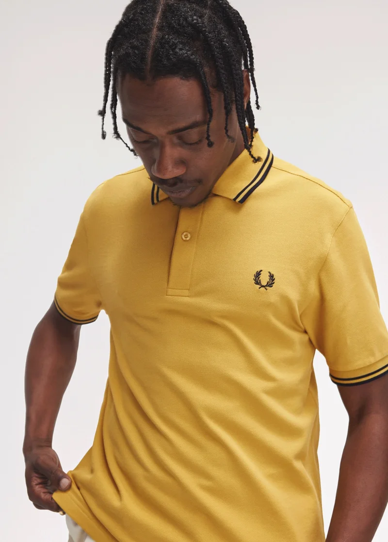 Black male model wears a Honeycomb M3600 Fred Perry Shirt with Navy tipping