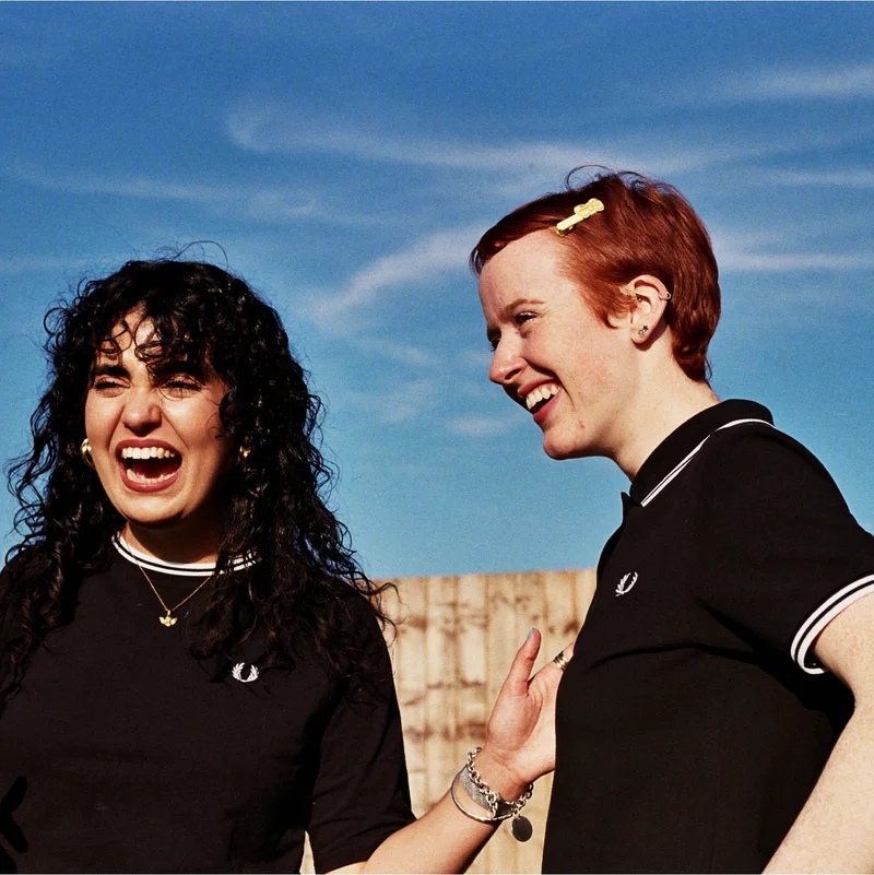 Two girls laughing in fred perry clothing