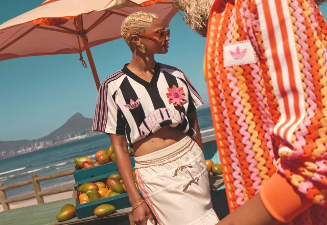 two women one wearing a black and white striped jersey and the other wearing a track jacket