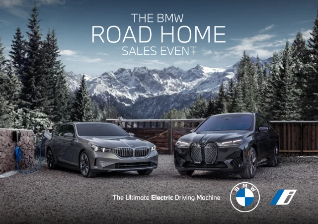 The BMW i5 and iX parked in front of snow covered trees with mountains in the back. The BMW Road Home Sales Event. The Ultimate Electric Driving Machine. BMW i.