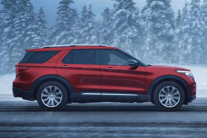 A Ford vehicle being driven down a snowy forest road.