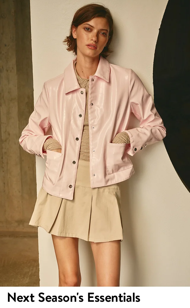 A woman wearing a jacket, stripe top and pleated skirt.