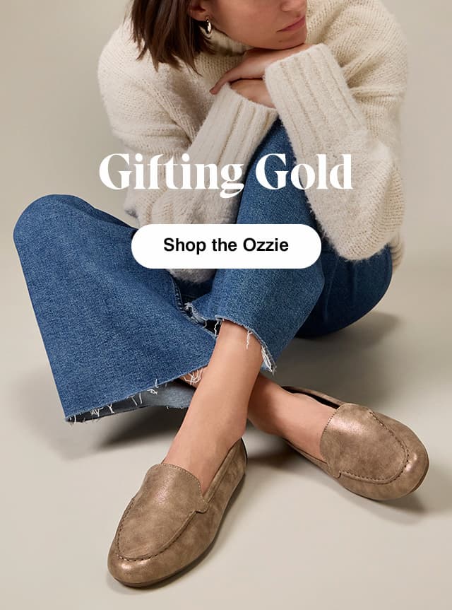 A woman sitting wearing a white turtleneck sweater, frayed-hem wide-leg jeans, and the Ozzie Loafer in Bronze. The email says Gifting Gold Shop the Ozzie