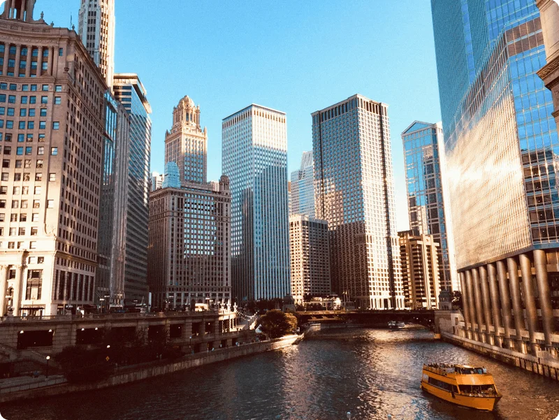 Image Description: A yellow water taxi cruising along the Chicago River, flanked by the city’s skyscrapers