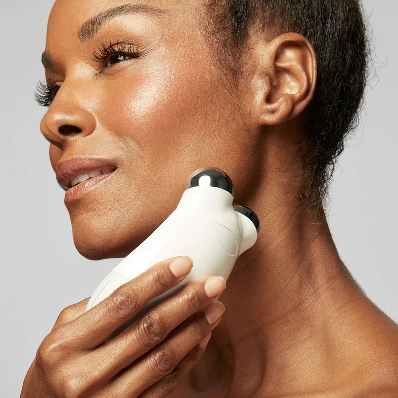 Woman holding Trinity Device to her neck to achieve a contoured look.