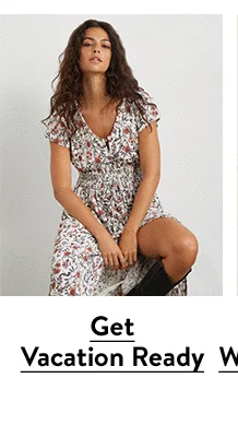 A woman wearing a floral-print dress with a smocked waist.