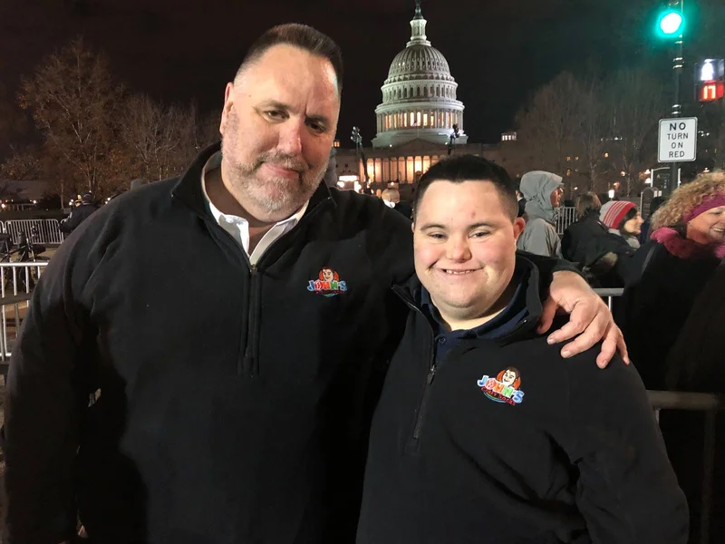 John and Mark with Mark's arm around John and they are standing in front of the U.S. Capitol