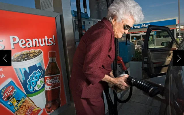 Marge Jetton, 100-year-old, fills up her car with gas at a gas station.