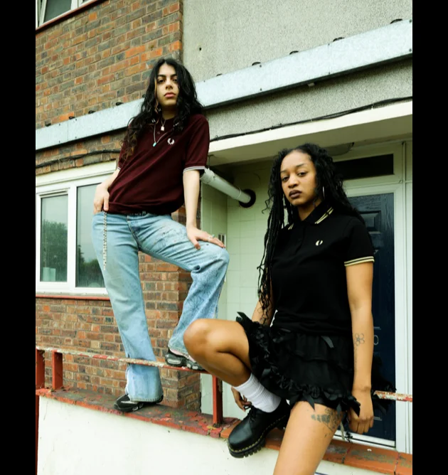 Two female fred perry ambassadors wearing fred perry shirts in an urban setting