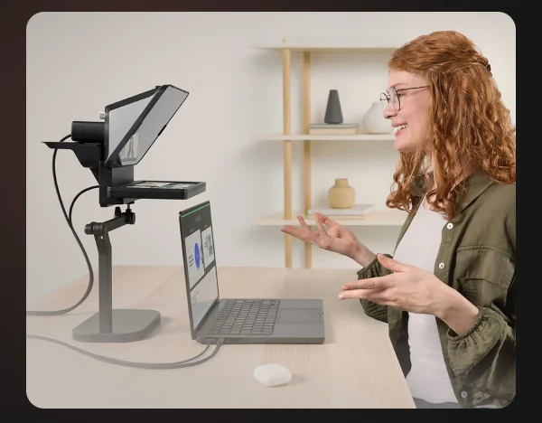 Woman sitting at desk in front of a laptop, giving a presentation using Elgato Prompter, Elgato Desk Stand, and Elgato Facecam Pro.
