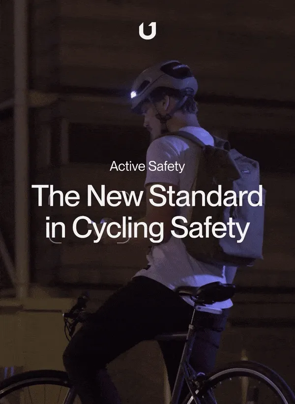 Cyclist wearing a smart helmet with integrated lights, showcasing safety features in a dimly lit urban environment.