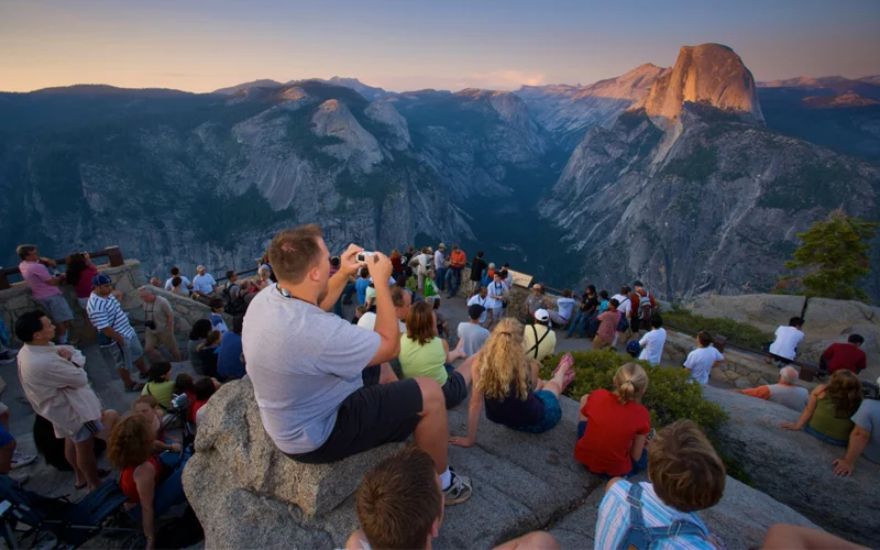 Visitors gather at Glacier Point to watch the sun set over Half Dome in California’s Yosemite National Park, which implemented a reservation entry system from 2020-2022.
