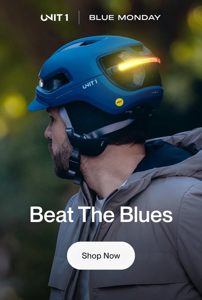 Side profile of cyclist wearing blue UNIT 1 AURA helmet during daylight ride, Blue Monday campaign visual.