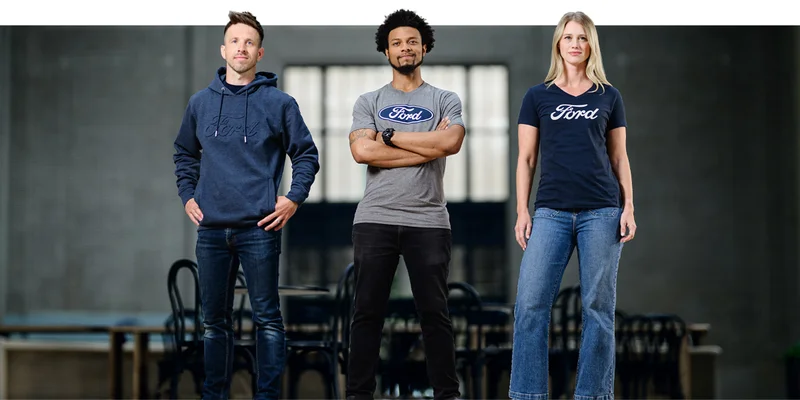 Three people in Ford merchandise standing in a warehouse