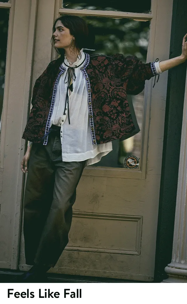 A woman wearing a white blouse with patchwork jeans.