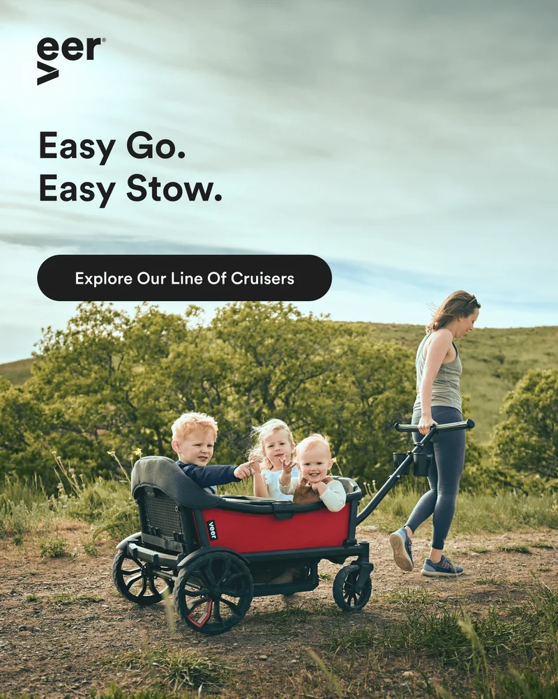 Woman pulling three children in the Cruiser XL on a dirt path