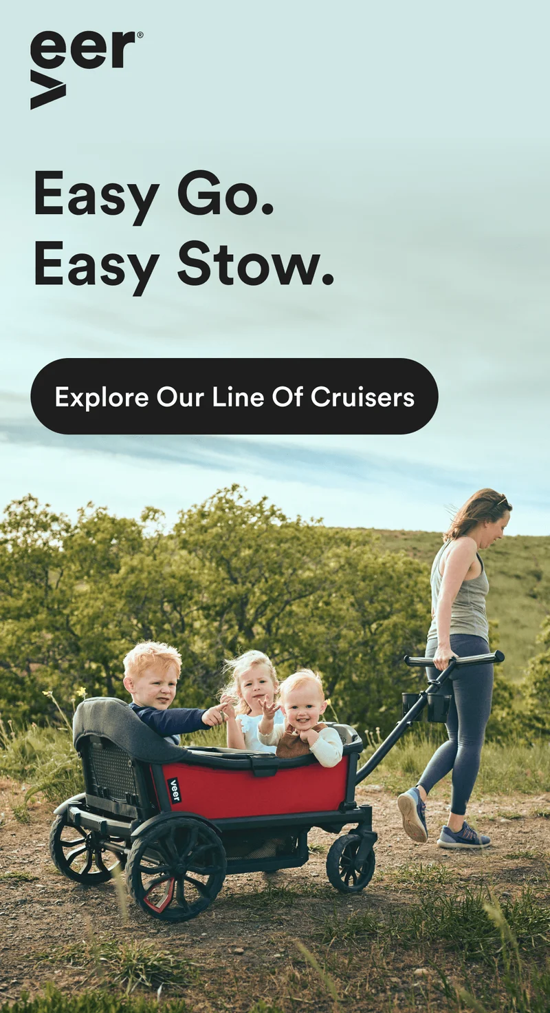 Woman pulling three children in the Cruiser XL on a dirt path
