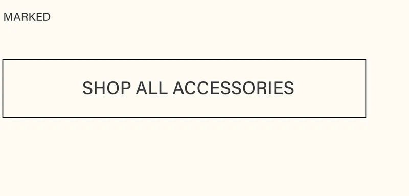 Rectangular button with a subtle black border, featuring 'SHOP ALL ACCESSORIES' in dark text on a cream background. Discover the MARKED accessories collection.