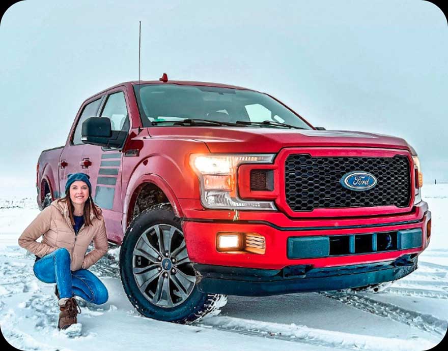 A woman next to a Ford truck.