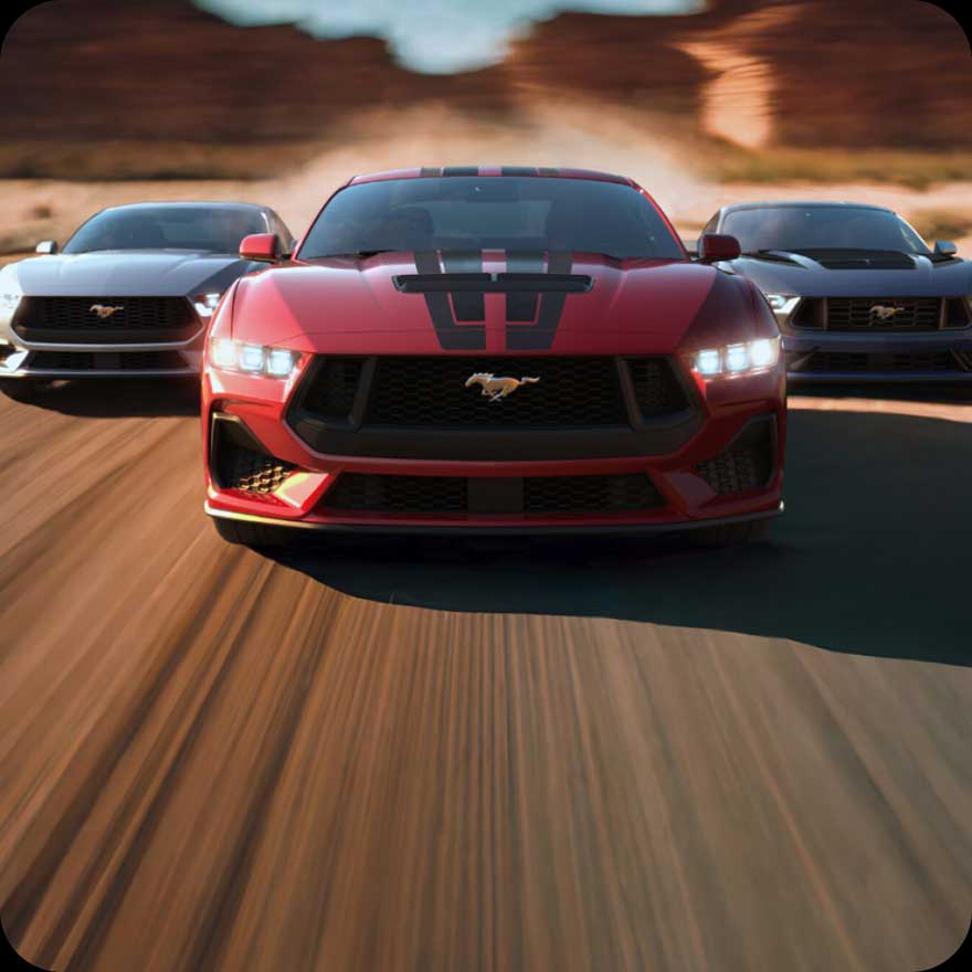 Three 2024 Ford Mustangs in motion.