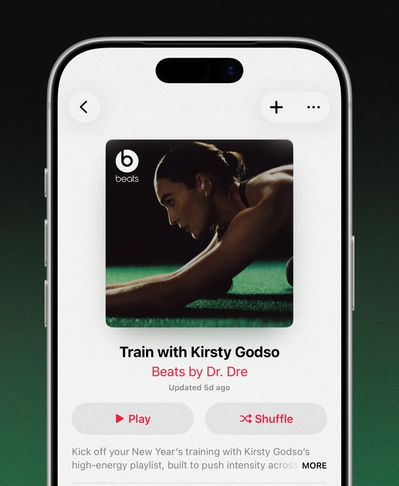An iPhone displays an Apple Music app screen featuring Kirsty Godso’s workout playlist.