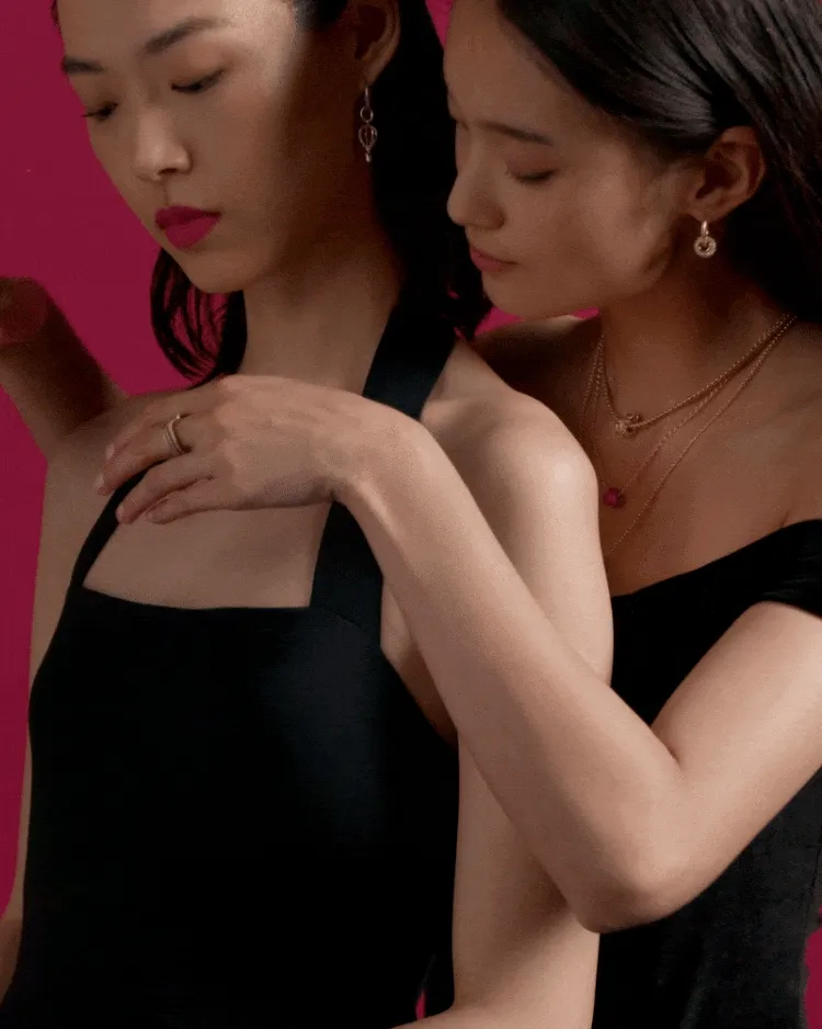 One woman helping another put on a Pandora necklace One woman helping another put on a Pandora necklace