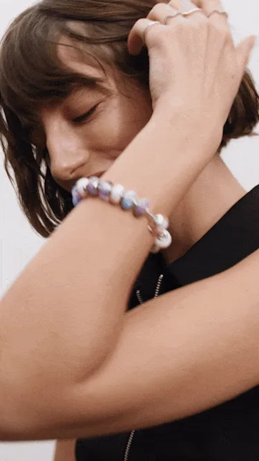 Model wearing fully loaded Murano charms on bracelet