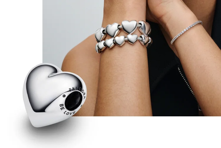 Model wearing bracelet loaded with Be Love Heart charms