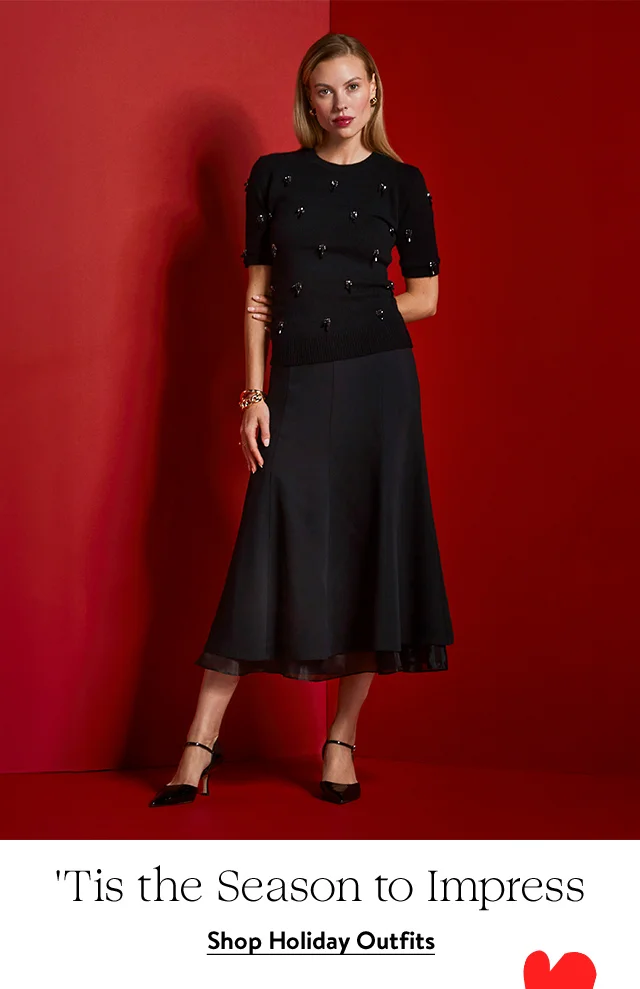 A woman wearing an embellished short-sleeve sweater, layered skirt, heels and accessories.