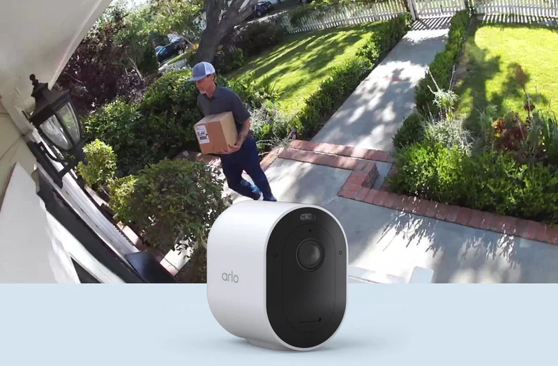 View of a package delivery at the front door of a home from the view of an Arlo Essential Wireless Security Camera.