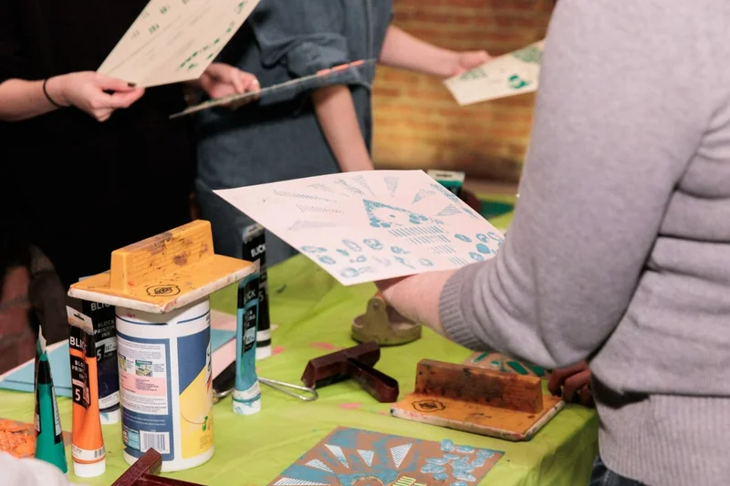 A photograph of people holding prints