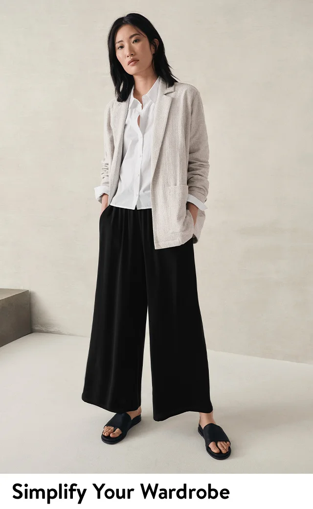 A woman wearing a beige blazer with a white button-front top and black trousers. A grey blazer.