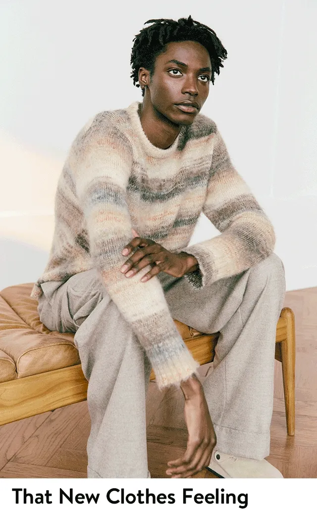 A man wearing a striped sweater and tan pants.