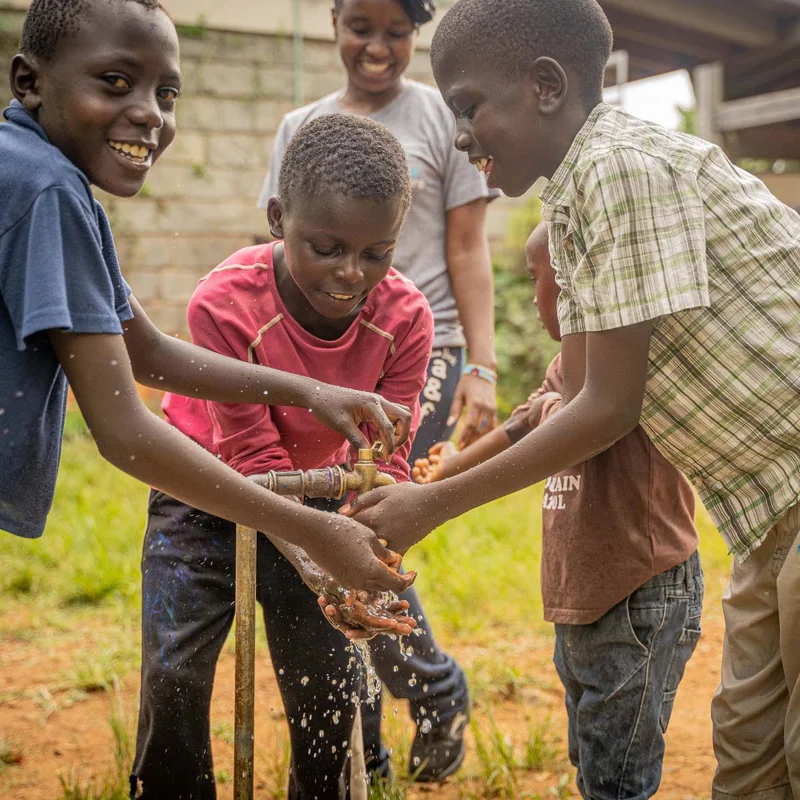 Kids washing their hands with clean well water