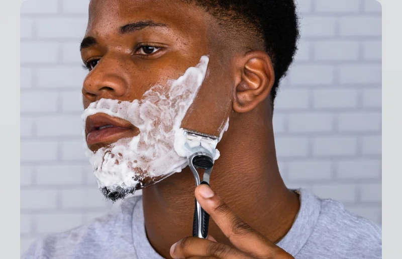 A man shaving his beard with Gillette SkinGuard Razor