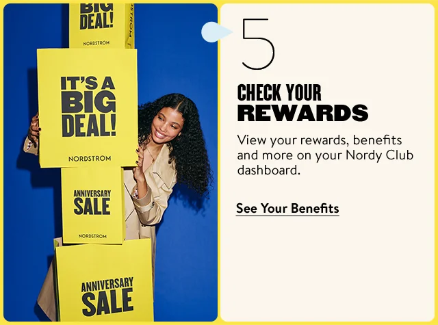 Check your rewards. A woman next to a tower of Anniversary Sale shopping bags.