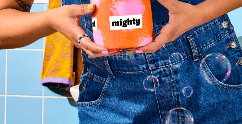 Image: Artsy woman holding Who Gives A Crap Poetry Edition TP. Poetic saying: "Soft and mighty"
