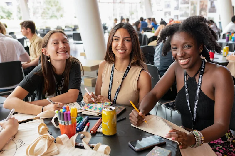 Three teens drawing and smiling