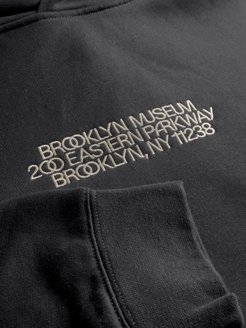 A close-up on a sweatshirt that says “Brooklyn Museum, 200 Eastern Parkway, Brooklyn, NY 11238”