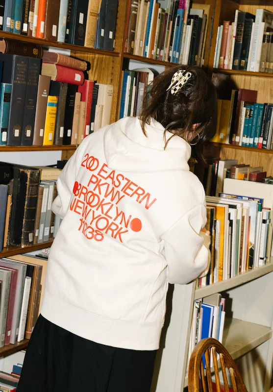 A woman wearing a sweatshirt that reads “200 Eastern Pkwy, Brooklyn, NY 11238””